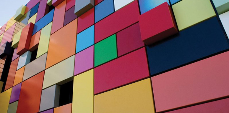 A wall covered in squares of brightly colored paint